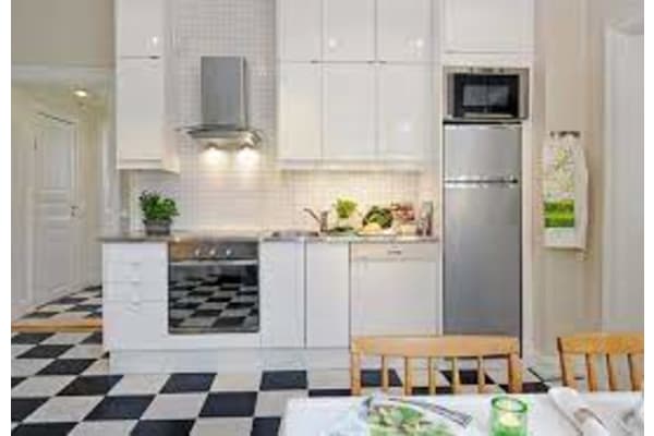 a white kitchen with a black and white checkered floor